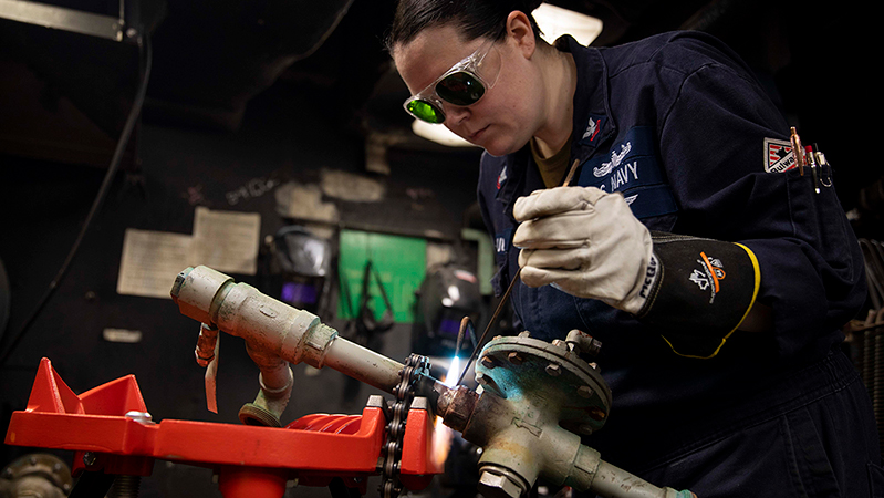 Navy Petty Officer 2nd Class Elizabeth McQueen repairs a low-pressure air compressor aboard the USS Gettysburg in the Atlantic Ocean, Aug. 2, 2024.